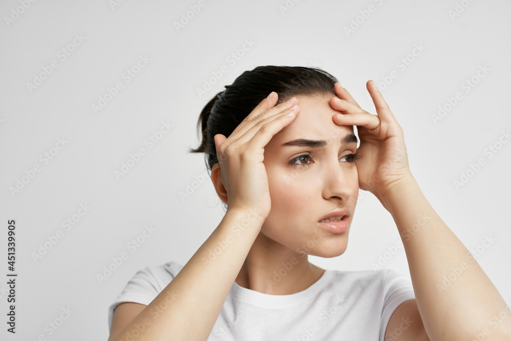 brunette in a white t-shirt holding her head discontent depression pain brunette in a white t-shirt holding her head discontent depression pain