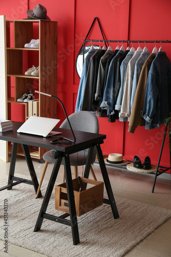 Interior of room with modern workplace and stylish female clothes © Pixel-Shot