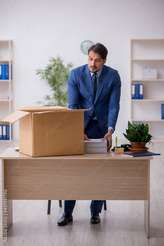 Young male employee in business relocation concept Young male employee in business relocation concept
