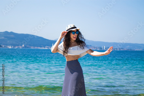 portrait of woman enjoying on the beach and waving hand