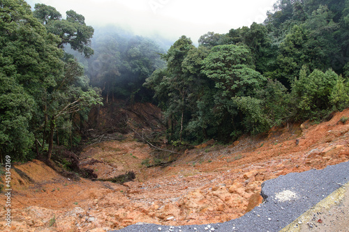 Collapse asphalt road cause by heavy rain due to foothill landslide photo