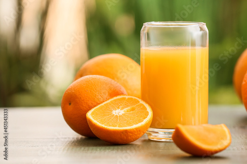 Glass of tasty orange juice on table outdoors, closeup