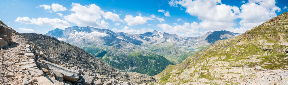 Fototapeta premium Idyllic alpine valley at high altitude high up on the mountains, scenic landscape rocky terrain and glaciers on the Alps, panoramic view