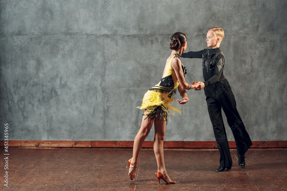 Fototapeta premium Young couple dancers dancing ballroom dance cha-cha-cha