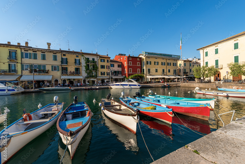 Small Port of the Lazise village with fishing boats, tourist resort on the coast of Lake Garda (Lago di Garda). Verona province, Veneto, Italy, southern Europe.