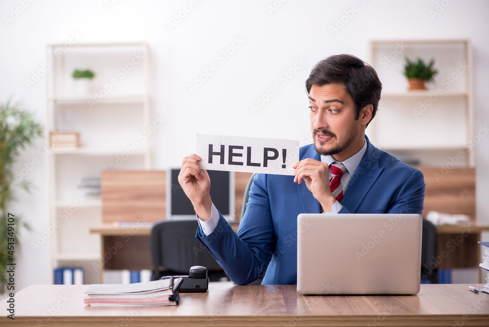 Young male employee sitting at workplace Young male employee sitting at workplace