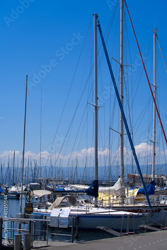 Port with sailing yachts at Lausanne Ouchy at a beautiful summer morning wich cloudy blue sky background. Photo taken July 29th, 2021, Lausanne, Switzerland.