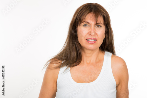 portrait senior caucasian woman with expression of disgust and discomfort on white background