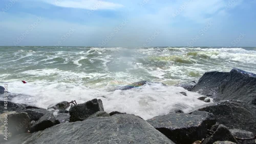 Sea waves with splashes and foam crash against the rocky shore Sea waves with splashes and foam crash against the rocky shore