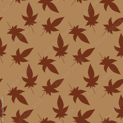 Seamless pattern with dark brown leaves on light brown background. Vector image.