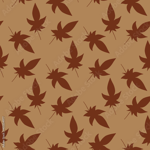 Seamless pattern with dark brown leaves on light brown background. Vector image.