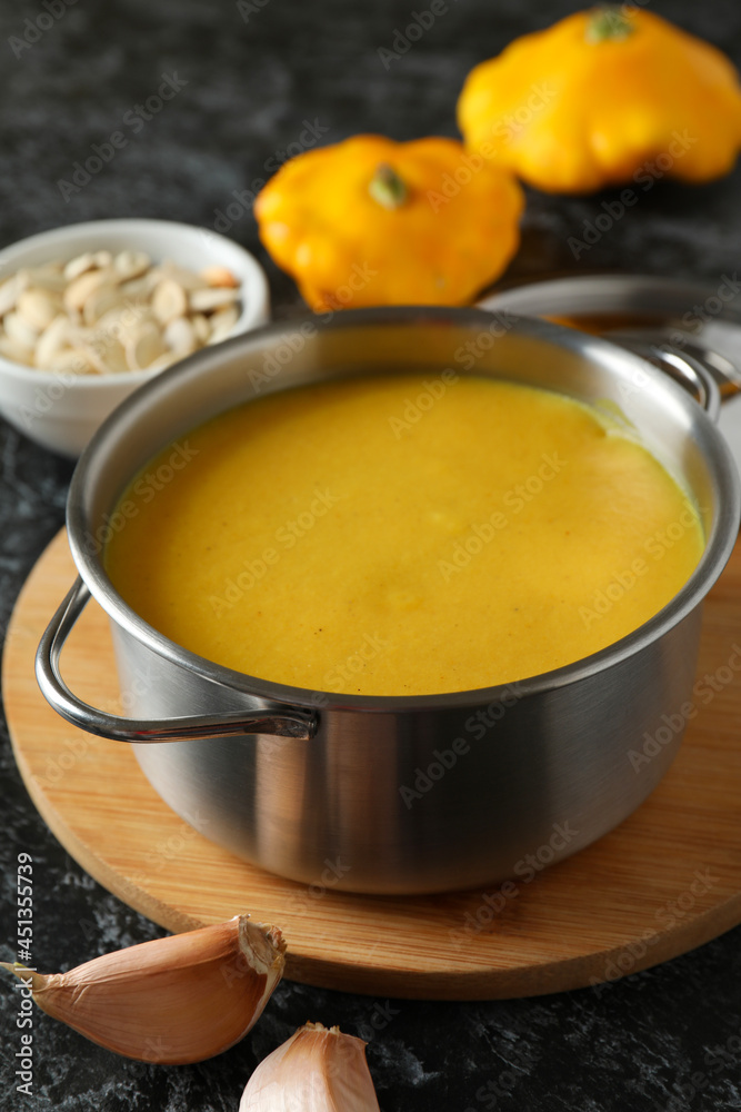 Concept of tasty food with pumpkin soup on black smokey table Concept of tasty food with pumpkin soup on black smokey table
