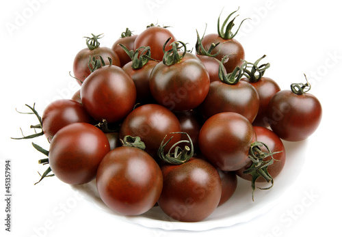 Ripe tomatoes in a white plate are isolated on a white background. photo