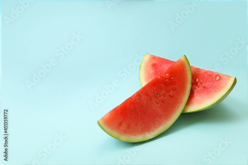 Ripe watermelon slices on blue background, space for text