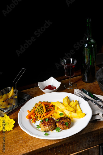 Homemade meatballs with french fries and vegetables