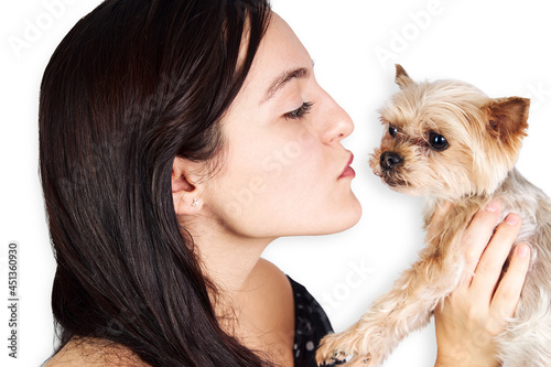 Hispanic teenage woman with small dog on white background. Pets concept