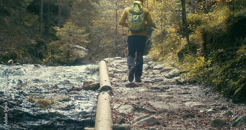 Traveler Man trekker with him dog walk around mountains in sunny day. Backpacker walking in Outdoors. Health care, authenticity, sense of balance and calmness. 4K Slow motion
