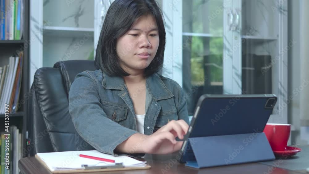 4k slow motion of Asian freelancer using tablet working video conference with a customer in home office. Marketing and financial. Deal with customers by online apps. Online selling and receiving order 4k slow motion of Asian freelancer using tablet working video conference with a customer in home office. Marketing and financial. Deal with customers by online apps. Online selling and receiving order