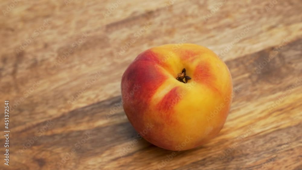 Fresh Ripe Peach Fruit Rotates on A Wooden Platter, Slow Motion, Macro, Close-up. A Vitamin-Rich Diet and Vegetarian Healthy Food. Fresh Ripe Peach Fruit Rotates on A Wooden Platter, Slow Motion, Macro, Close-up. A Vitamin-Rich Diet and Vegetarian Healthy Food.