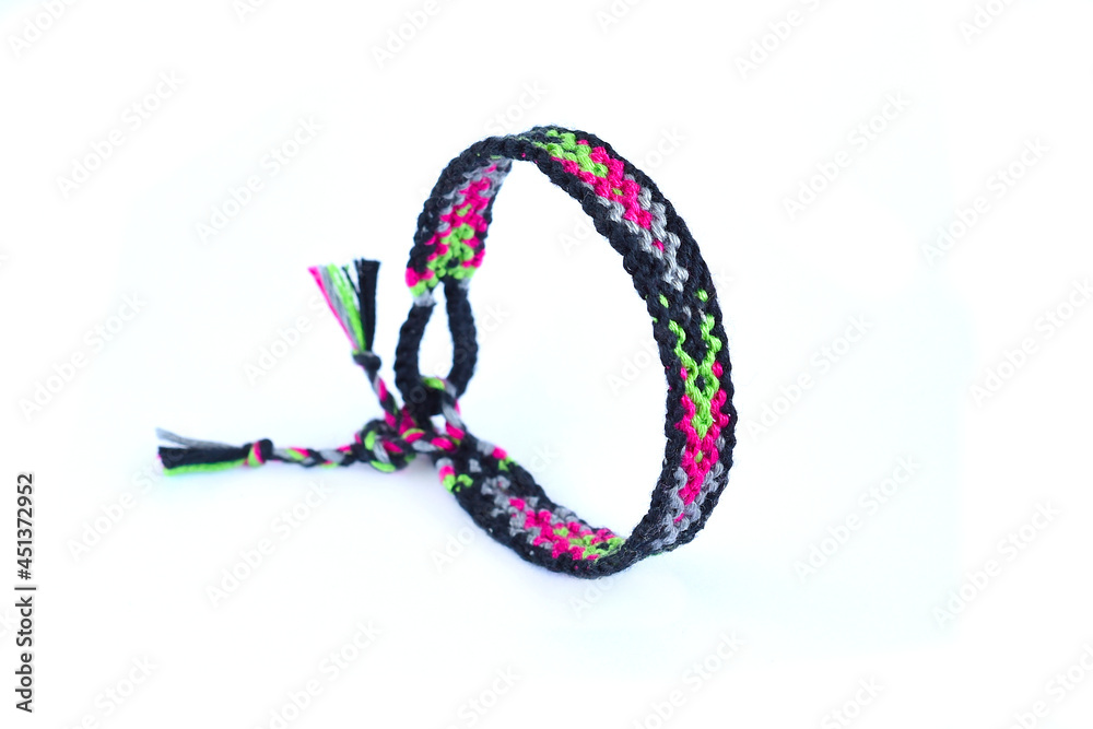 Woven friendship bracelet with bright colorful pattern handmade of thread isolated on white background Woven friendship bracelet with bright colorful pattern handmade of thread isolated on white background