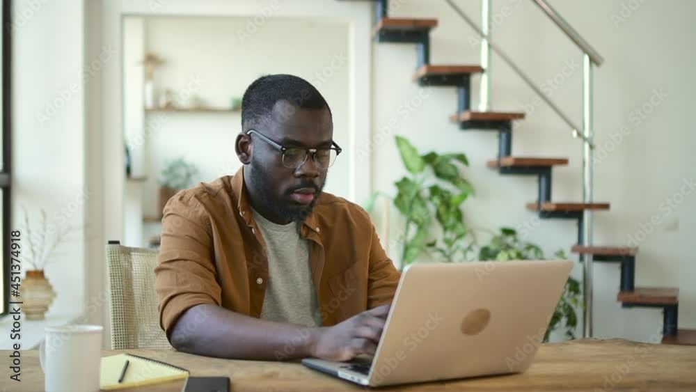 Businessman typing and working with laptop while sitting at table in home office. Businessman typing and working with laptop while sitting at table in home office.