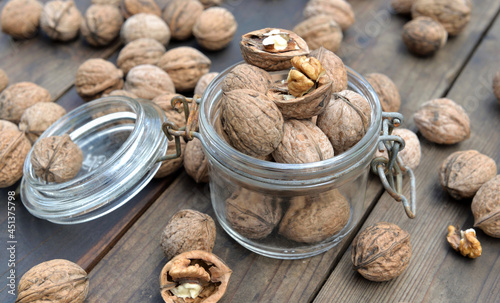 shelled  walnuts in a glass jar among others on wooden table