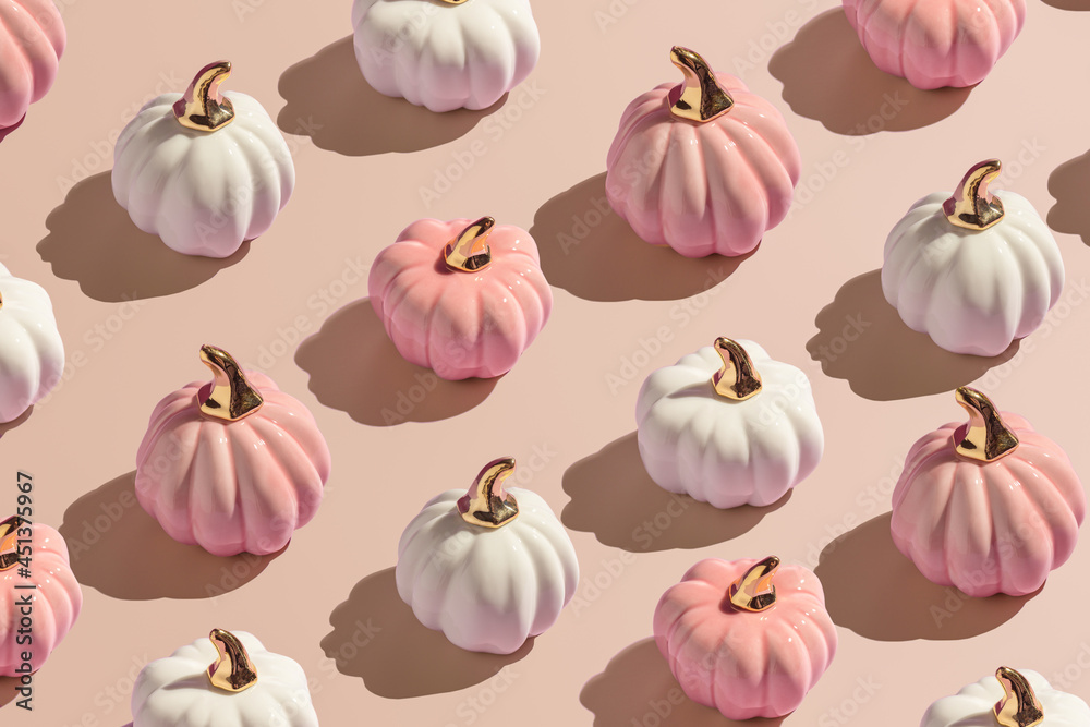 Flat lay pattern from white and pink decorative autumn pumpkins on beige background in hard light. Flat lay pattern from white and pink decorative autumn pumpkins on beige background in hard light.