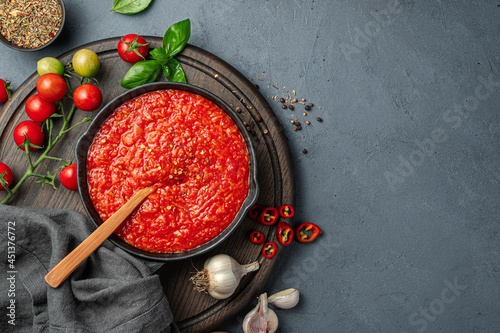 Italian marinara sauce and ingredients on a dark background. photo