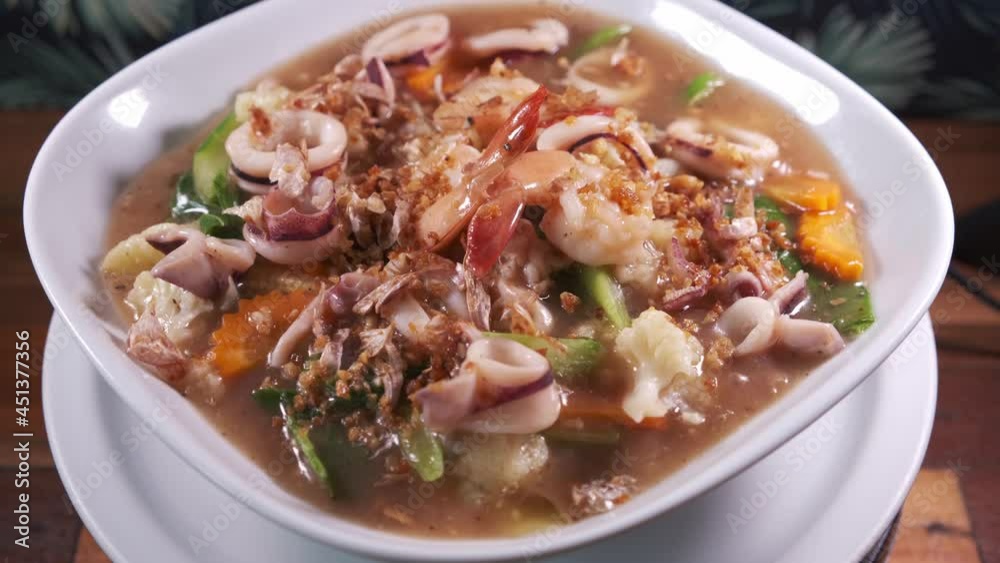 Authentic Thai Cuisine Dish with Freshly Cooked Squid in a Spinning Bowl. Indoor Studio Set Up. Authentic Thai Cuisine Dish with Freshly Cooked Squid in a Spinning Bowl. Indoor Studio Set Up.