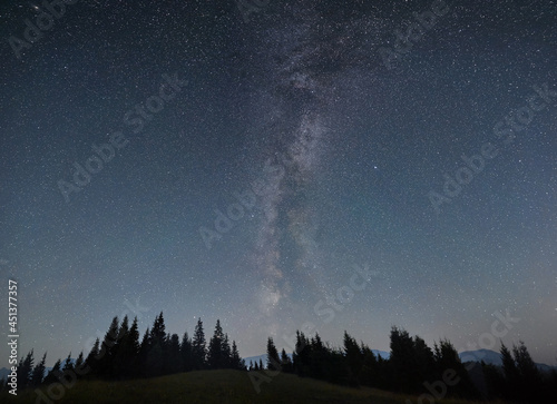 Night sky full of stars, Milky way in the mountains in summer. Galaxy above the hillside, beautiful night scene. Space background. Copy space. Astrophotography