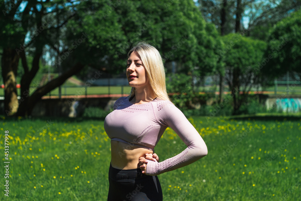 Young caucasian blond-haired woman in sportswear is doing yoga in the park. Outdoor workout. Yoga poses. Young caucasian blond-haired woman in sportswear is doing yoga in the park. Outdoor workout. Yoga poses.