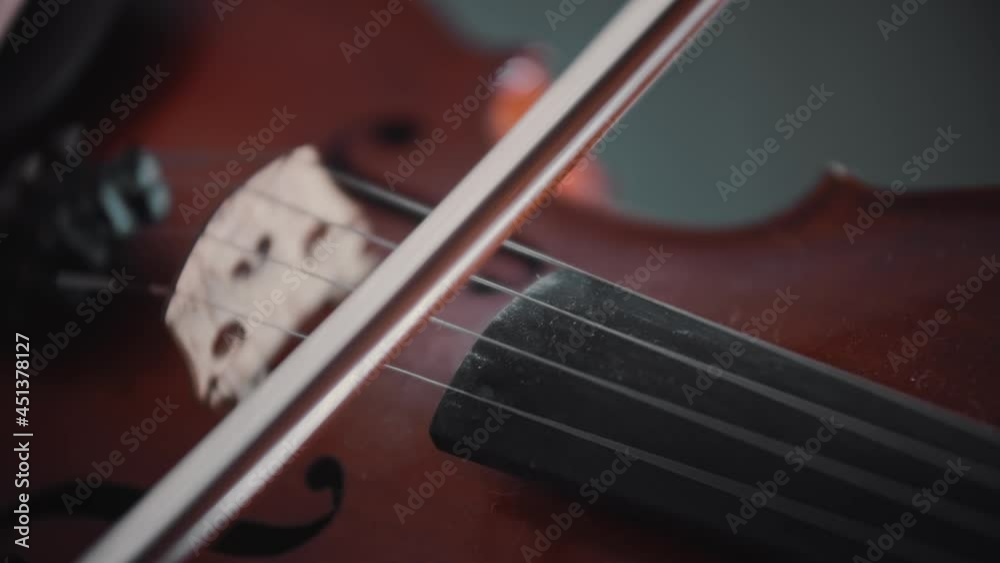 Young woman playing violin - playing with a bow on the strings Young woman playing violin - playing with a bow on the strings