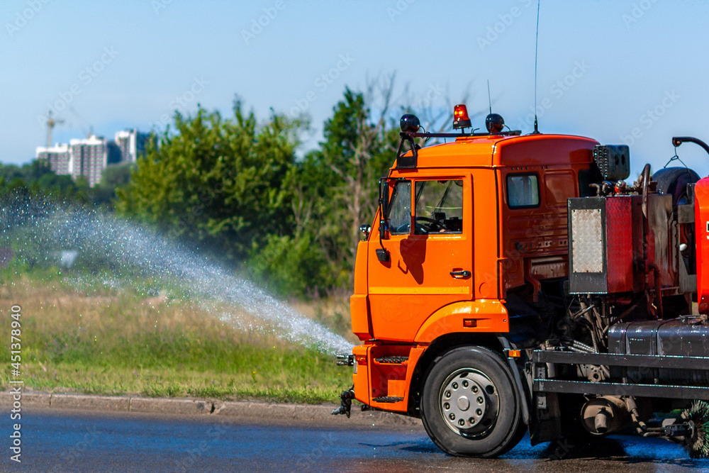 High-pressure sweeper cleaning the road. The concept of maintenance or cleaning of city streets from debris, dust, bacteria, viruses and dirt by public utilities.