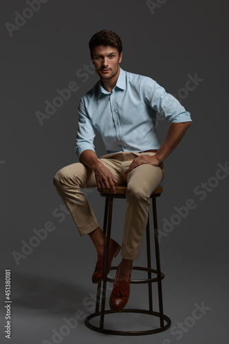 Young confident business man sitting on bar chair