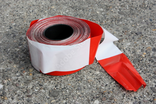 Rolle Absperrband rot/weiss auf einem Betonboden
