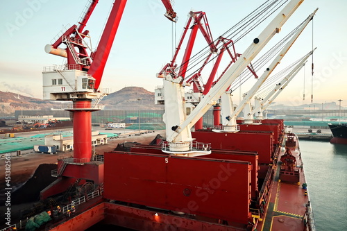 Cargo terminal for unloading bulk cargo of iron ore by shore cranes and grabs. Huludao, China, November, 2020. photo