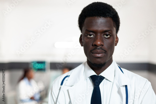 Portrait of african american doctor looking at camera in hospital ward. Black man with coat and stethoscope with medical recovery occupation. Professional healthcare clinic surgeon  medic
