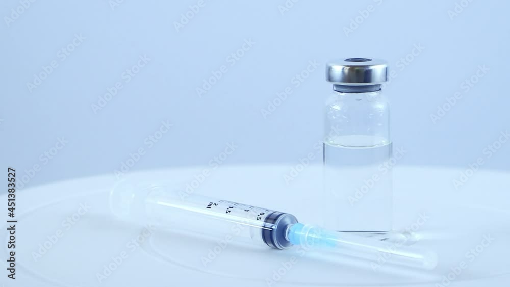 Hands in blue medical gloves hold syringe and glass vial with vaccine. Doctor involved in immunization of population against the coronavirus. Slow motion. Hands in blue medical gloves hold syringe and glass vial with vaccine. Doctor involved in immunization of population against the coronavirus. Slow motion.