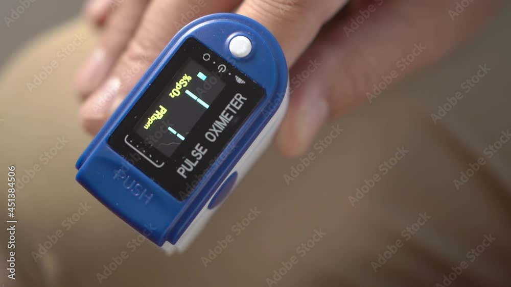 Close-up of a man using a pulse oximeter to measure oxygen saturation and heart rate, a man using a pulse oximeter to measure oxygen saturation in pandemic covid19, medical surveillance at home