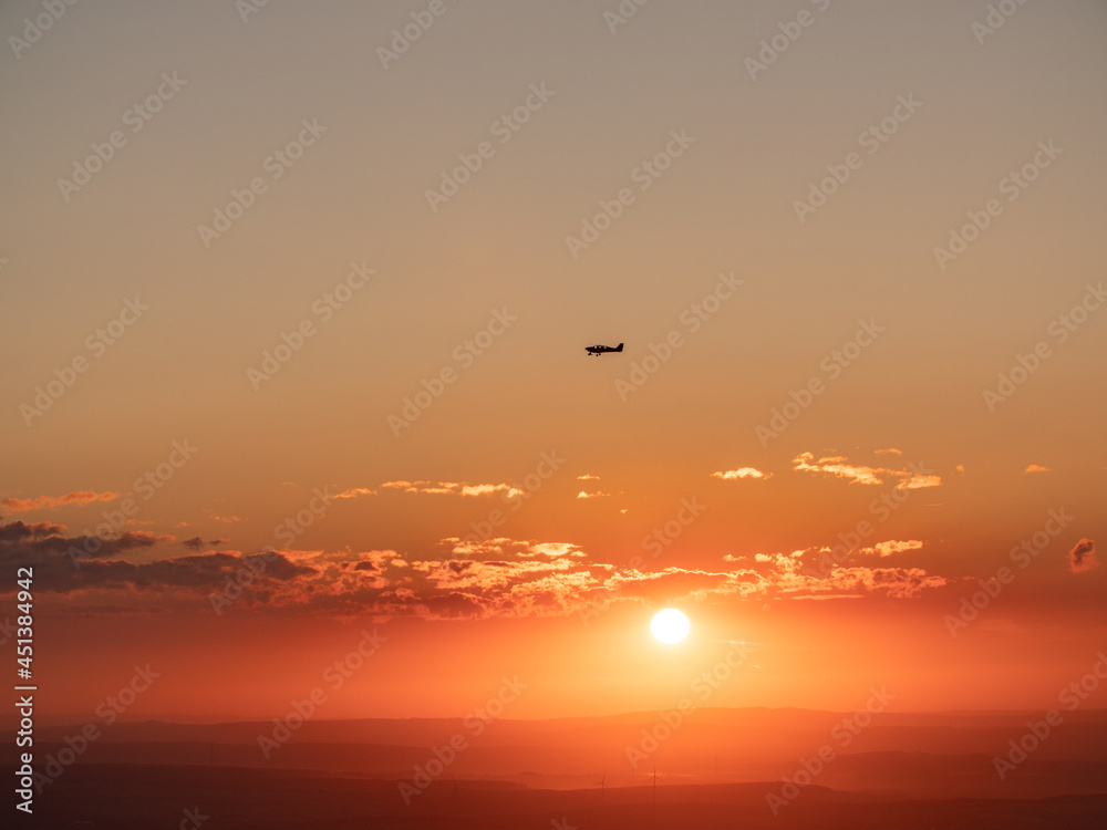 A plane flies through the sunset. Hochtaunus Feldberg 