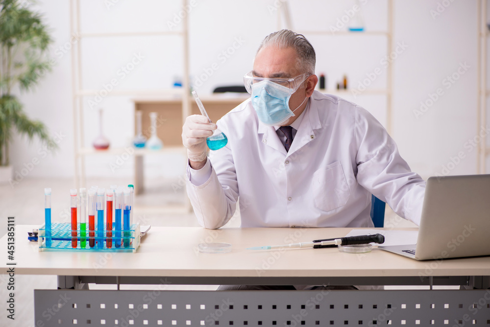 Old male chemist working in the lab during pandemic