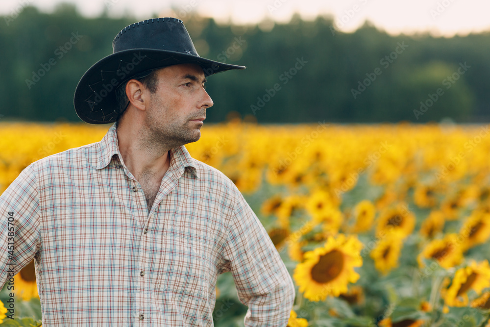 Man farmer standing in a sunflower field Man farmer standing in a sunflower field