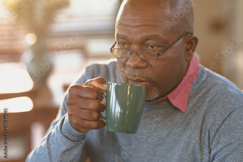 Senior african american man in stinging the modern kitchen drinking a coffee