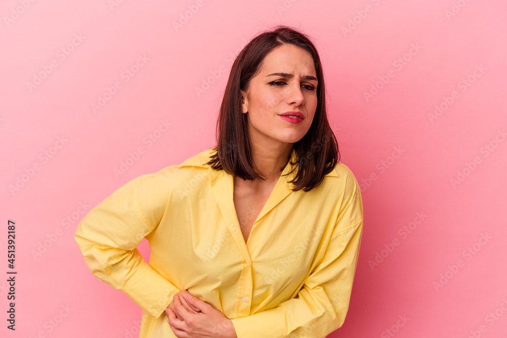 Young caucasian woman isolated on pink background having a liver pain, stomach ache. Young caucasian woman isolated on pink background having a liver pain, stomach ache.