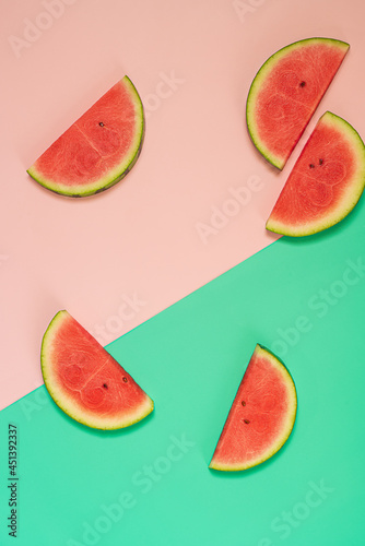 Fototapeta Naklejka Na Ścianę i Meble -   Slices of fresh watermelon on pink and green background.Flat lay with copy space.Trendy food photography.