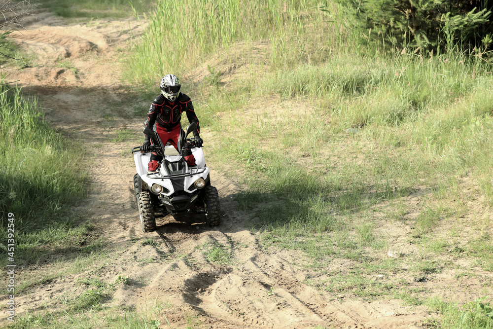 Man driving modern quad bike on sandy road. Extreme sport Man driving modern quad bike on sandy road. Extreme sport