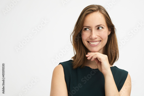 portrait of a cute young woman looking to the left while being thoughtful and smiling
