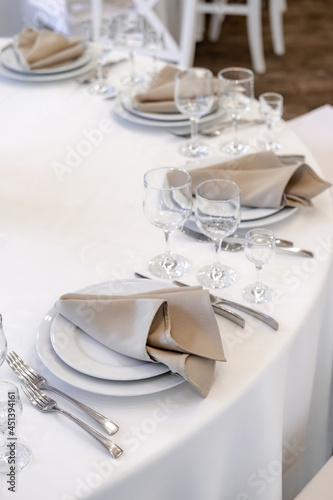 Luxurious wedding table decoration for reception of guests with stylish napkins, cute natural flower. Wedding restaurant decoration