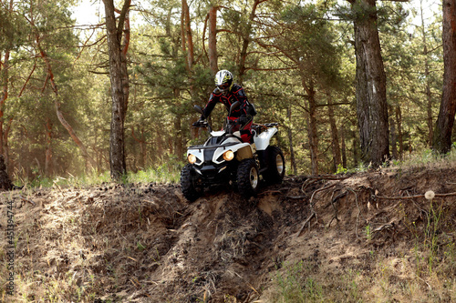 Man driving modern quad bike in forest. Extreme sport