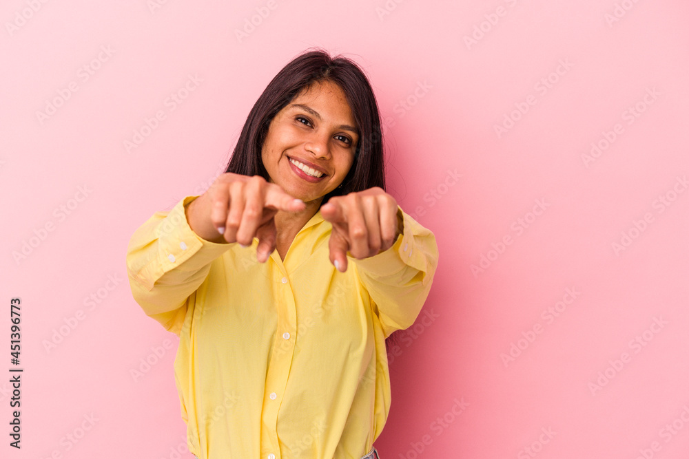 Young latin woman isolated on pink background pointing to front with fingers. Young latin woman isolated on pink background pointing to front with fingers.